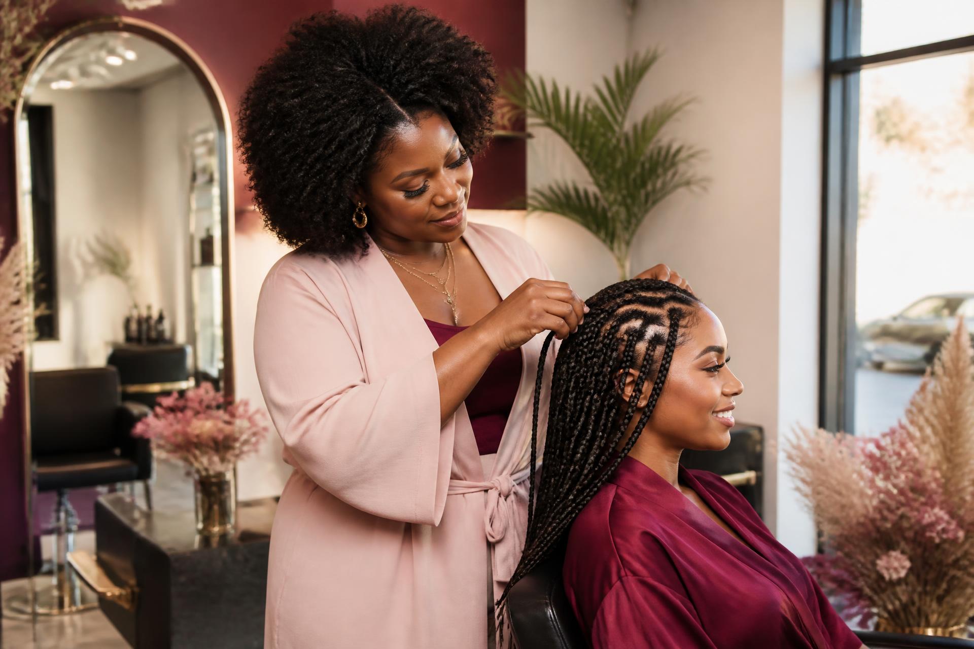 Natural hair salon stylist completing braids for a client